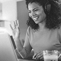 Woman waving at a laptop screen