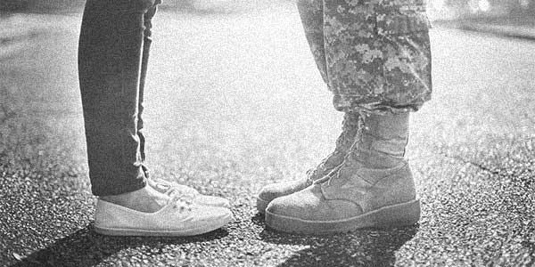 Military couple, one in boos and one in sneakers.