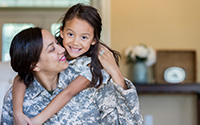 Child hugging a woman in a military uniform