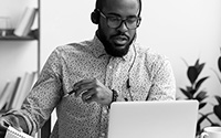 Man working on a laptop wearing a headset